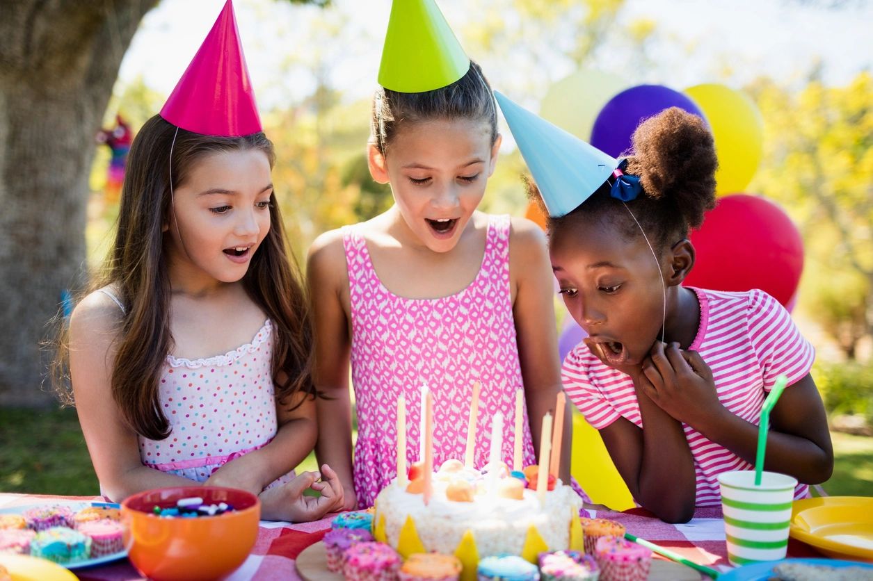 Children celebrating birthday with cake and candles